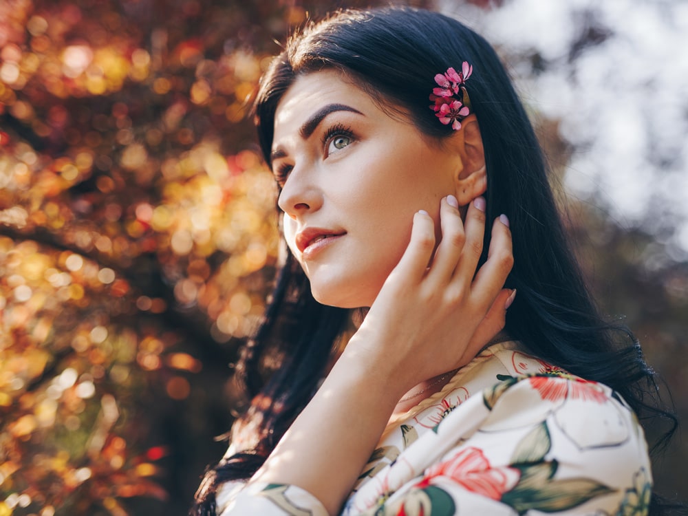 dromerige vrouw met bloem in haar in park
