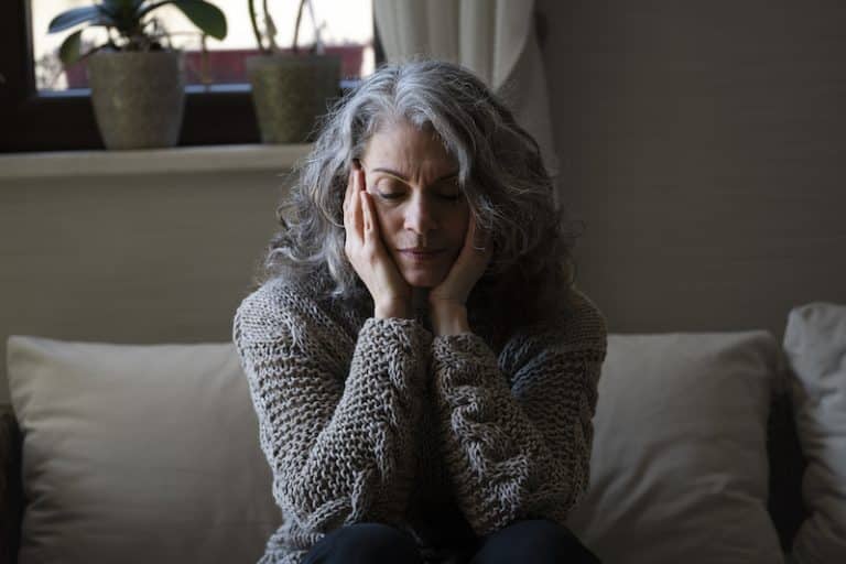sad elder woman sofa