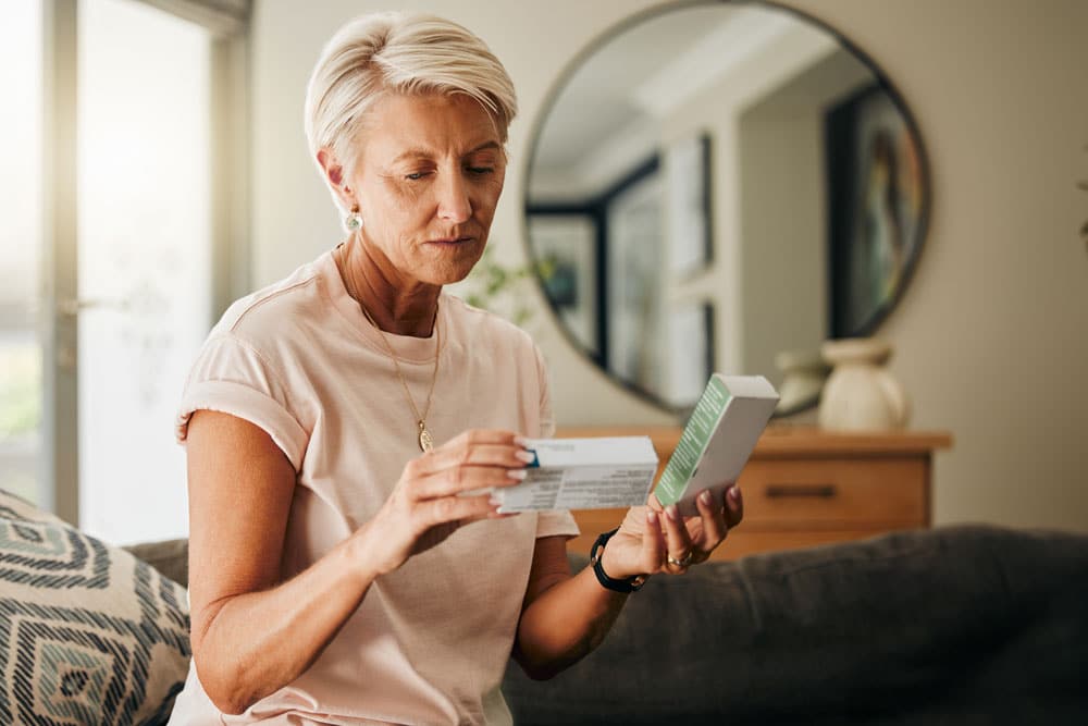 senior woman medicine pills and reading instruction