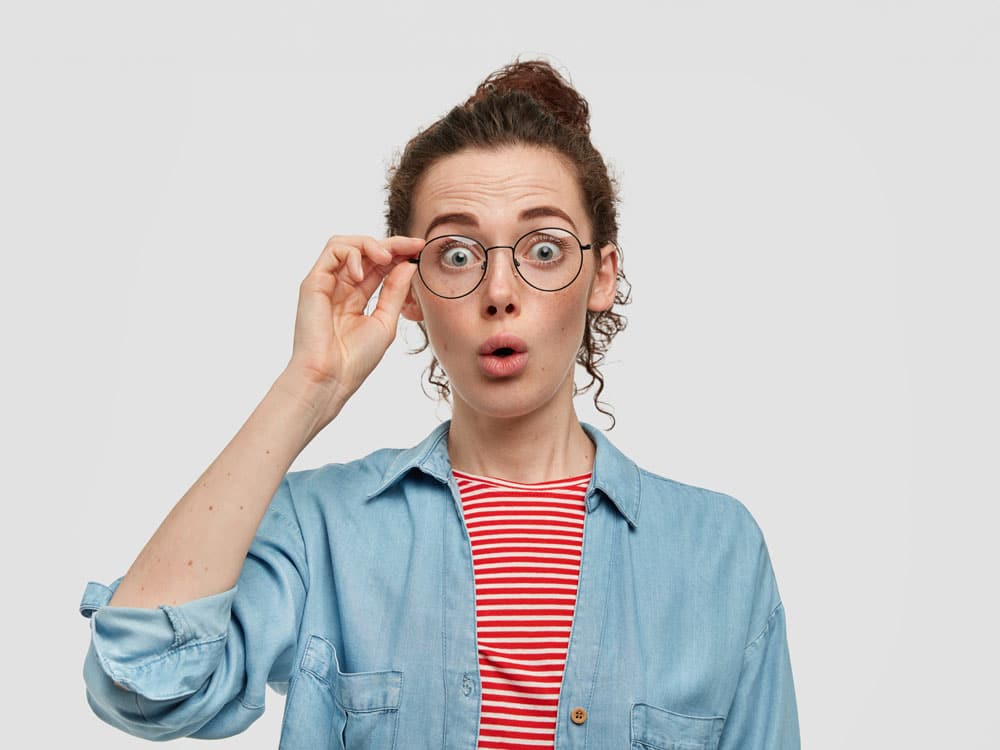 verrast jonge vrouw met sproetengezicht stares