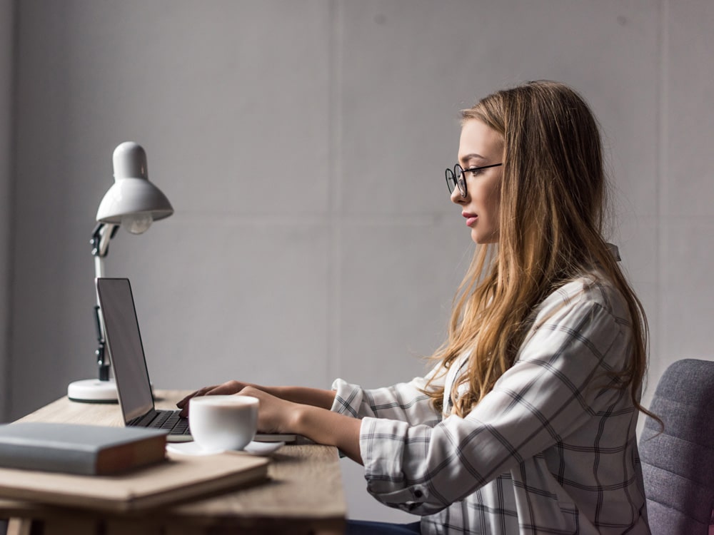 zijaanzicht van gefocuste jonge zakenvrouw werkend