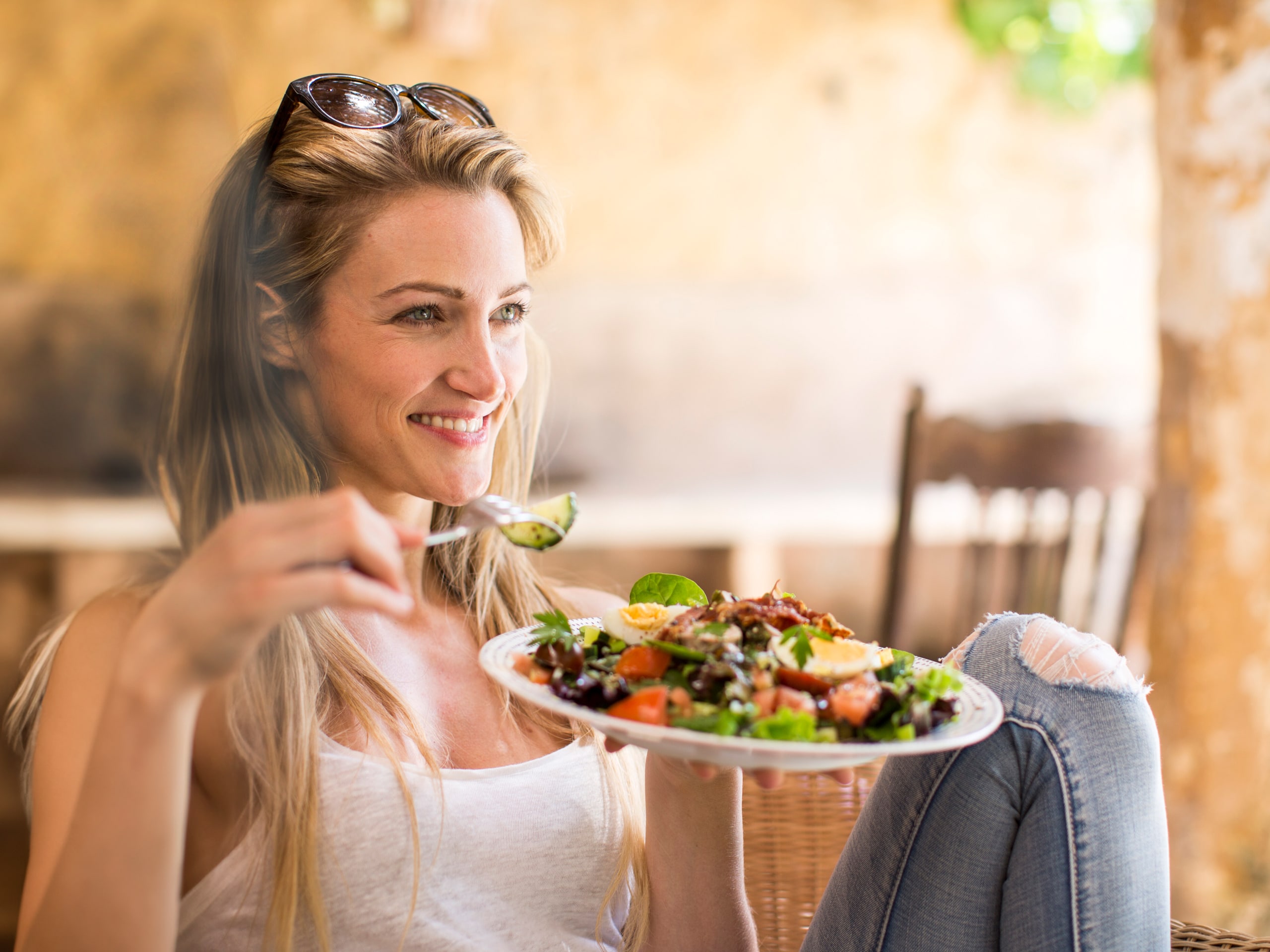 jonge vrouw ontspannend op tuin patio eten salade