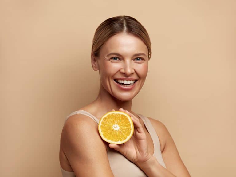 mooie vrouw glimlachend met sinaasappelfruit positief