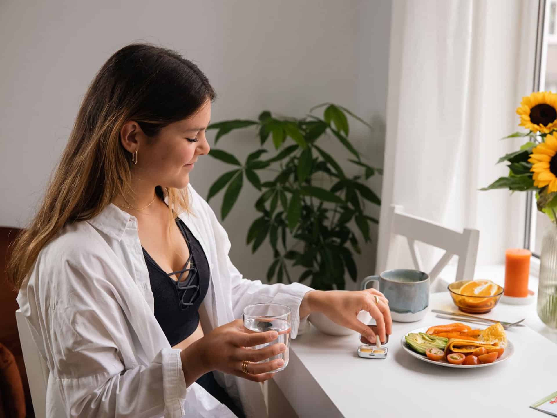 mooie vrouw met water viatminen en gezond maaltijd