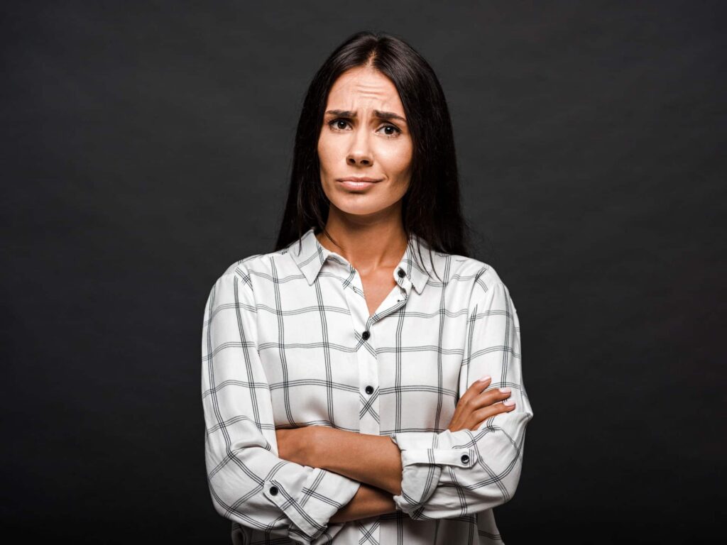 ontevreden vrouw staand met gekruiste zwarte achtergrond