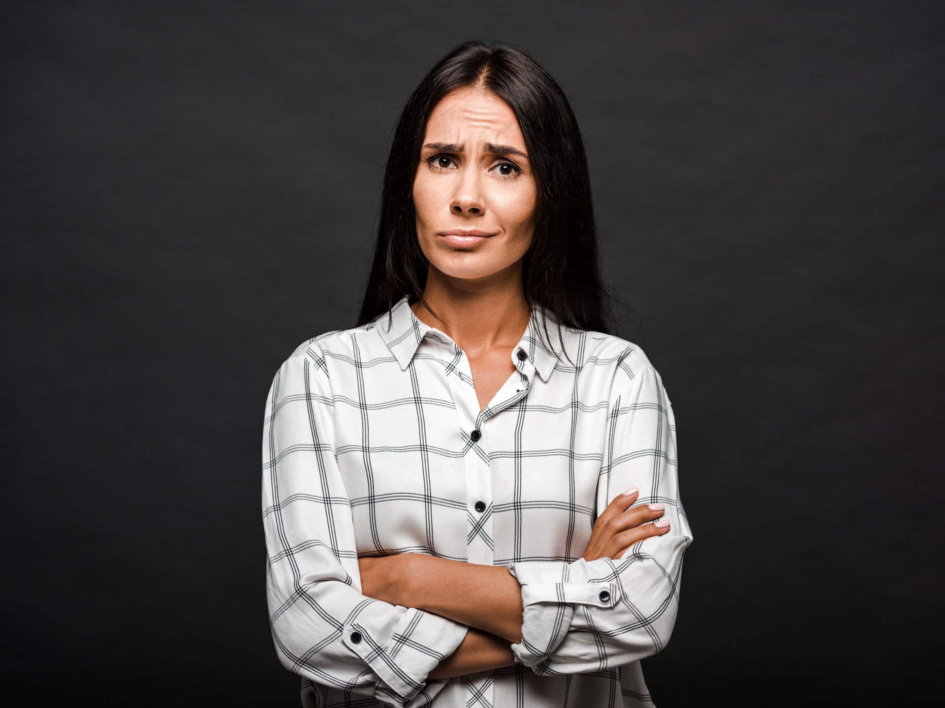 ontevreden vrouw staand met gekruiste zwarte achtergrond